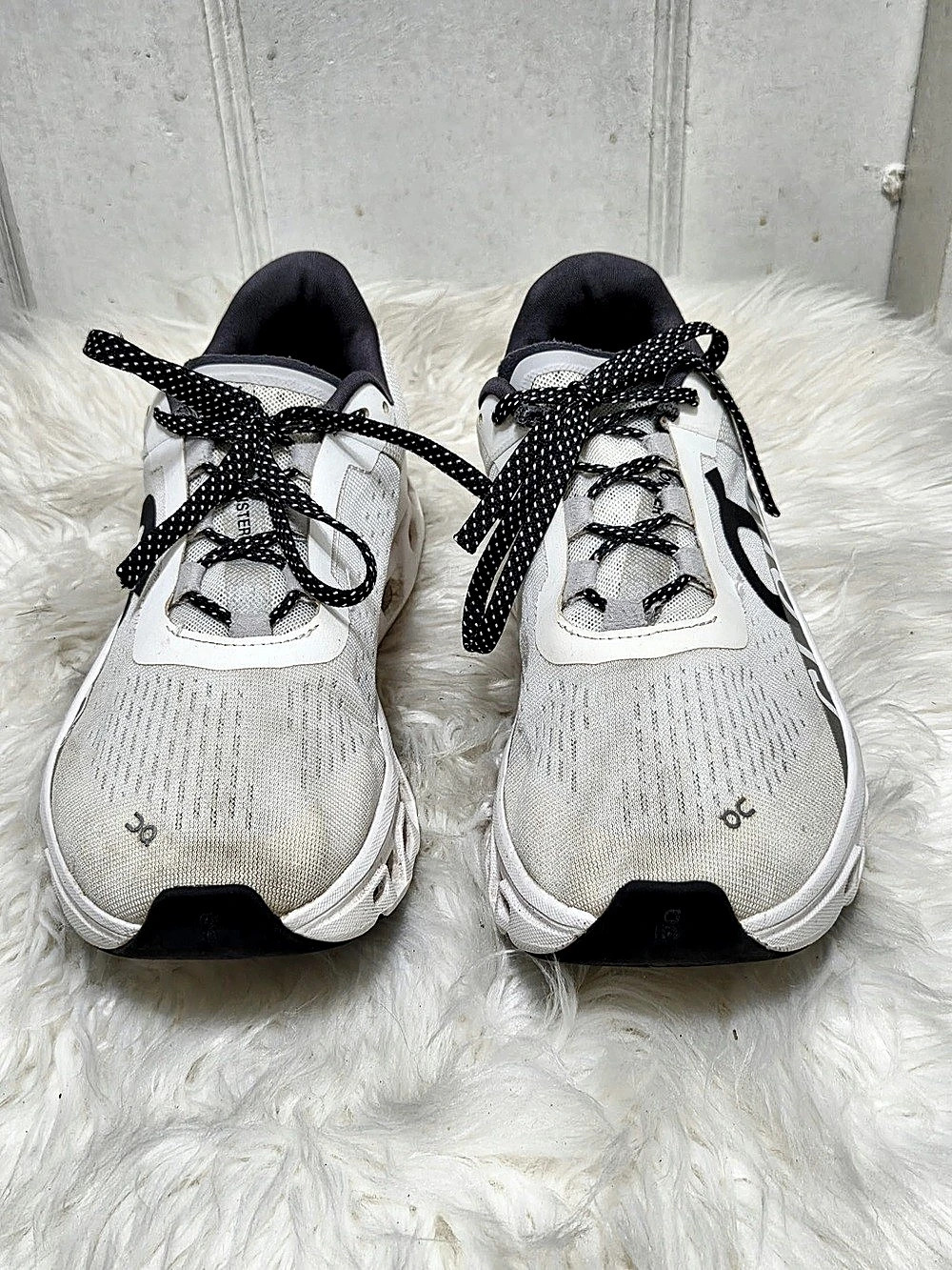 On Cloudmonster running shoes chunky CloudTec sole in white.